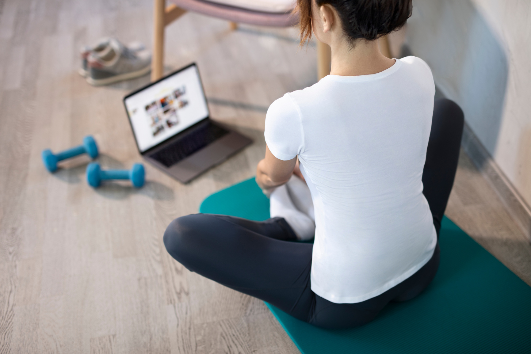 Young slim woman at home training. Workout online with a laptop. Stretching exercise. Online sport lessons.
